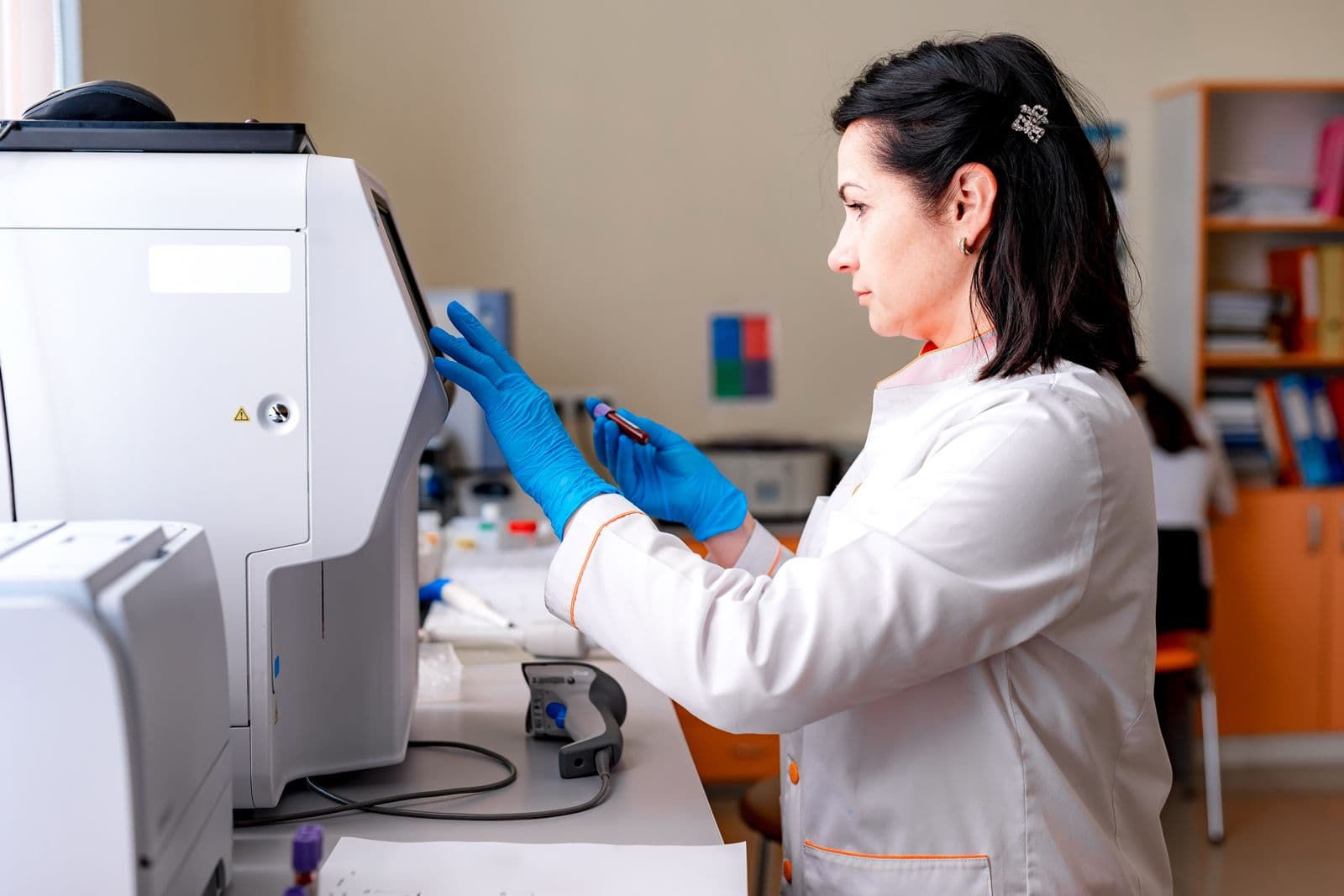 Lab technician operating a clinical analyzer machine